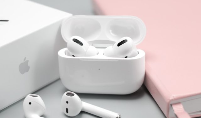 Apple's AirPods Pro 2 Upgrade Strategy Locks Users into Ecosystem Apple AirPods Pro 2 earbuds in white case on a wooden table, highlighting the new design and charging case.