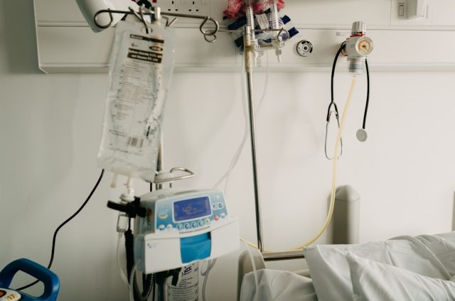 FDA Approves Tarlatamab as New Treatment for Aggressive Lung Cancer A medical researcher holds a vial of Tarlatamab drug with a lung cancer diagram in the background.