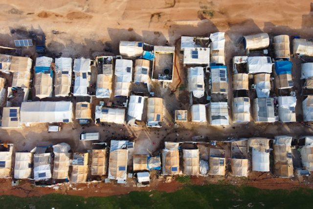 Sudanese Famine Worsens Six Months After Global Famine Review Warning Emaciated children and adults sit in a makeshift camp in Darfur, with aid workers distributing limited food supplies.