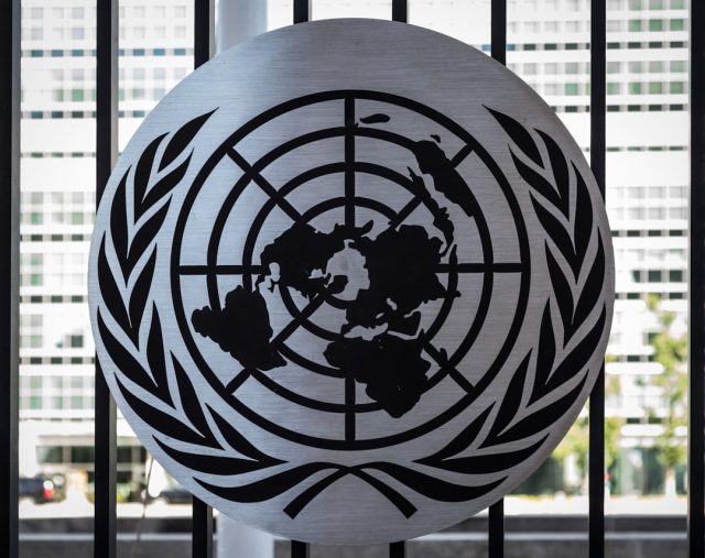 British National to Lead UN Humanitarian Office Amid Fresh Strains Thomas Fletcher stands at a podium with UN logo, preparing to lead humanitarian coordination efforts in October 2024.