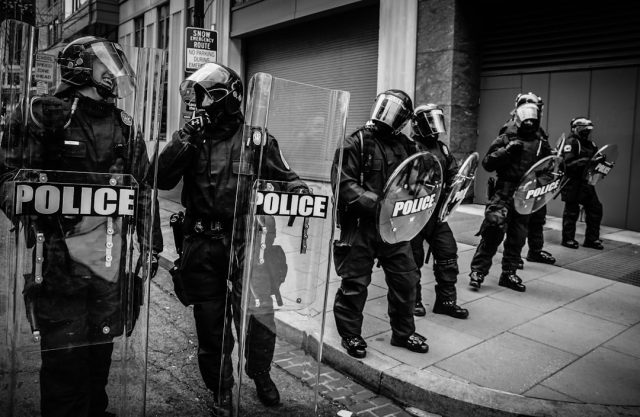 SWAT Training Demands and Risks Examined After California Blast Injures 16 Orange County SWAT training center exterior cordoned off after blast shattered windows and scattered debris across the concrete yard.