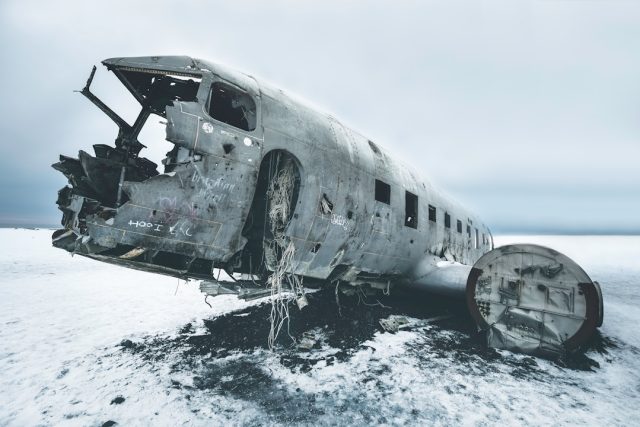 Safety Questions Arise After Fatal Crash at London Southend Airport Fire crews spray foam on a burning twin-turboprop aircraft beside the Southend runway at dusk.