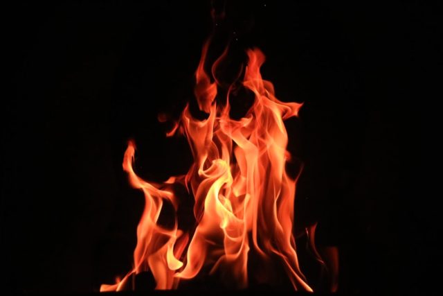 Bukavu Fire Kills 14; Rapid Growth Strains City's Infrastructure Firefighters navigate a narrow alley in Bukavu, with dense makeshift housing and smoke rising from a burned structure.