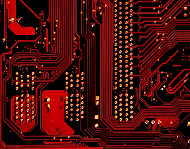 OpenAI Acquires Jony Ive's Hardware Start-Up io in AI Device Push Jony Ive stands at a lab bench showing a sleek prototype device to OpenAI engineers under bright studio lights.