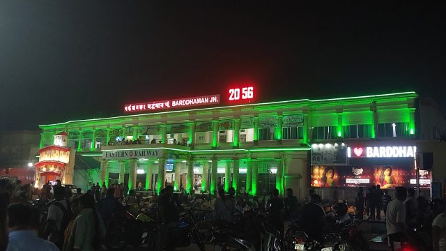 Water Tank Collapse Kills Three at Indian Railway Station Crowd gathered at Barddhaman Junction railway station after a water tank collapsed, with debris scattered on the platform.