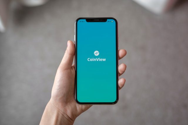 Facebook's experimental division launches Tuned, a private app for couples Phone screen shows pastel Tuned chat interface with shared photo, song and mood sticker between two cartoon avatars.