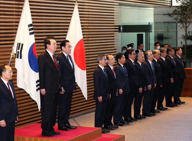 Japan South Korea Export Controls Meeting Split-screen video call shows Japanese and Korean officials at desks during marathon trade negotiations.