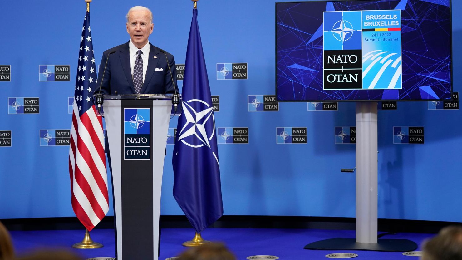 Joe Biden Brussels Ukraine March 2022 President Joe Biden speaks at a podium in Brussels with European flags behind him, addressing Western allies on Ukraine aid.