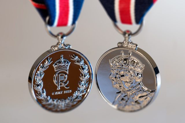 King Charles III Coronation Medal A nickel silver King Charles III Coronation Medal featuring left profiles of the King and Queen Camilla on a blue ribbon.