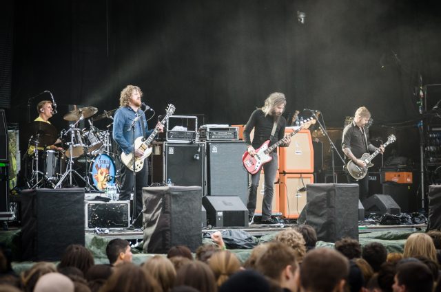 Mastodon Mastodon onstage in a packed venue, one guitar microphone stand suddenly empty after Brent Hinds' removal.