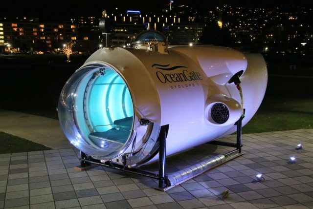 OceanGate Submersible Implosion Kills Five Near Titanic Wreck Site A deep-sea submersible descends through dark ocean waters toward the Titanic wreck site on the ocean floor.